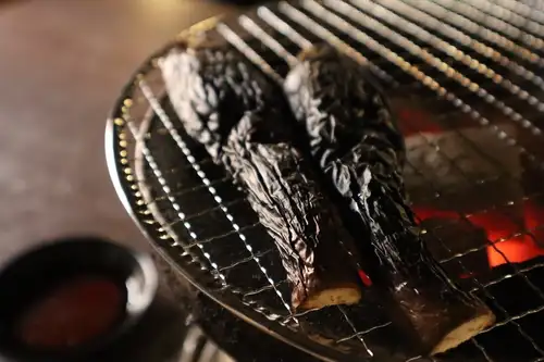 Grilled eggplant over charcoal with mala sauce