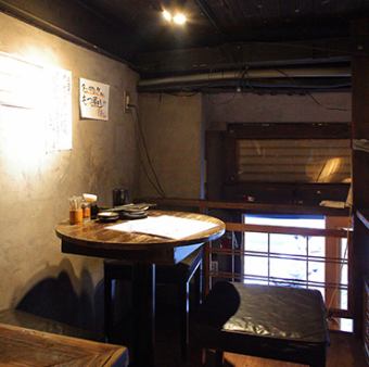 【中2階(丸テーブル)】木目を基調とした昭和レトロで落ち着いた雰囲気の中、お食事をお楽しみいただけます。会社帰りの軽い1杯から、親しい方とのお食事にぜひご活用ください。広々としたテーブルで、料理をシェアしながら楽しい時間を過ごせます。テーブル席ならではの開放感と、落ち着いた雰囲気をお楽しみください。