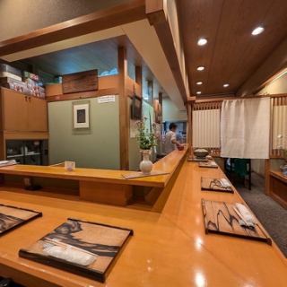 【カウンター席】木目を基調とした店内にはカウンター席を8席ご用意。店内を彩るお花や植物が飾られた空間で、こだわりの食材を活かした料理をお楽しみいただけます。目の前では職人が調理する過程も観ることができ、食欲を一層と引き立てます。店主との会話をお楽しみいただきながら、美味しい料理をご堪能ください。