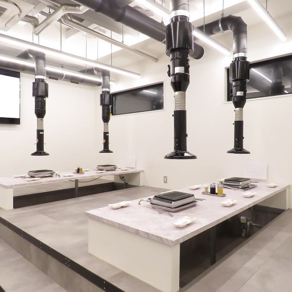 店内は、モダンでミニマルなデザインが印象的なテーブル席です。座って楽しめるスタイルのお席には、各席に専用のグリルが設置されており、目の前で焼きながら食事を楽しめるスタイルです。頭上には大型の排気フードが備えられており、煙や匂いを気にせず快適に過ごせる空間です。