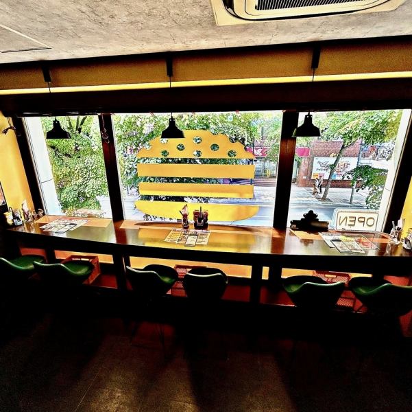 窓際カウンター席からはすすきのの街が一望できる！窓一面のストアロゴも映えポイント。