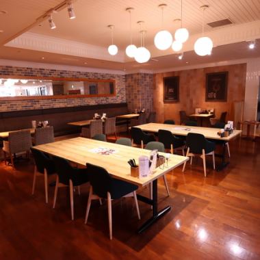 テーブル席をメインとした店内は天井が高く、のんびりとお過しいただける雰囲気です。統一感のあるカラーリングのフロアをペンダントライトが優しく照らし、心の落ちつく環境でお食事やお酒をお楽しみいただけます。