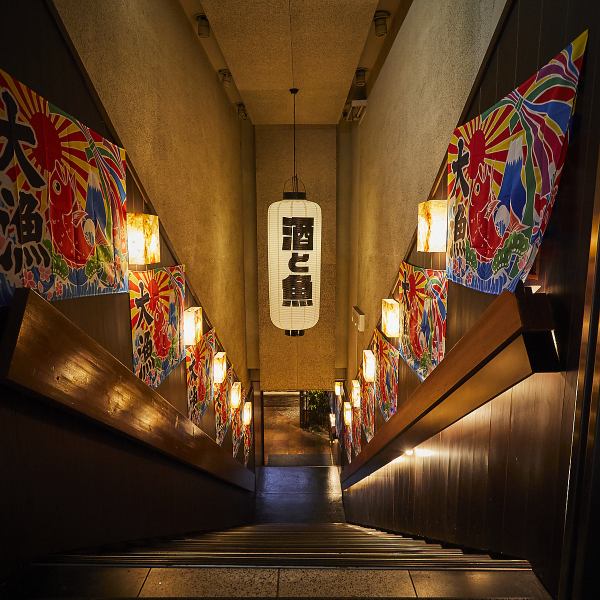 名古屋駅徒歩1分。提灯の灯りと大漁旗が並ぶ階段を降りると、そこには活気あふれる大衆酒場の世界。店内に入る前からワクワクするような演出でお迎えします。全国47都道府県の地酒や旬の鮮魚、名古屋名物を気取らず楽しめる空間は、仕事帰りの一杯や仲間との飲み会にもぴったり。ふらっと立ち寄れる、賑わいある酒場です。