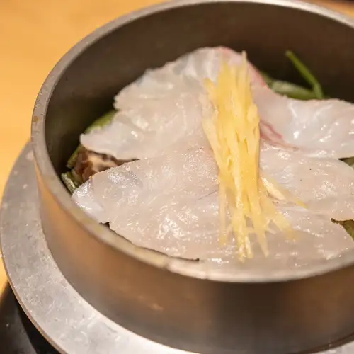 日式米饭与鲷鱼和大量野生蔬菜一起用锅煮熟。