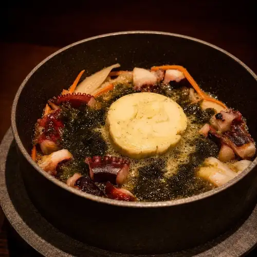 Octopus and seaweed with basil butter in a rice pot