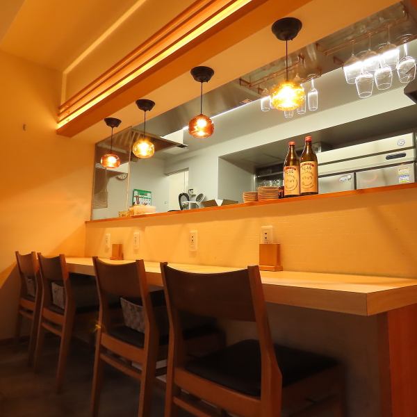 【カウンター席：2名席×2卓】木目の温もりを感じるカウンター席は、お料理が出来上がるまでのワクワク感を満喫できる特等席。炉端焼きの香ばしい匂いが漂い、五感で楽しめます。肩を並べて座り、美酒を傾けながら、大人の時間を過ごすのに最適です。デートにも◎