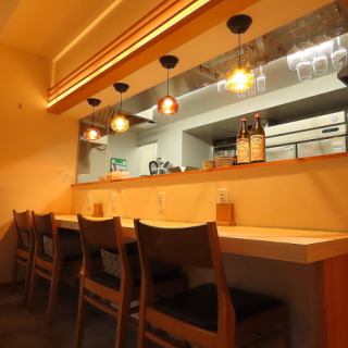 【和の趣が漂うカウンターで一杯】日本酒の瓶が並ぶカウンターは、和の雰囲気たっぷり。職人の手仕事を眺めながら、静かに一杯楽しめる特等席です。