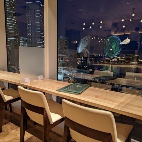 Counter seats perfect for a date and overlooking the night view of Minato Mirai.