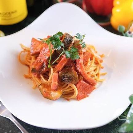 Bacon and colorful vegetables pasta in tomato sauce