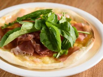 Raw ham arugula pizza