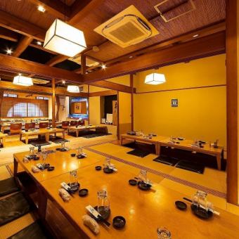 【1階｜掘りごたつ個室】最大50名様まで：掘りごたつ個室を仕切る襖を開ければ、最大50名様までご着席いただける広々個室に早変わり。奥まで見渡せる開放的な空間が魅力です。掘りごたつなので席の移動も楽々！大人数で集まるご宴会にぜひご利用ください。