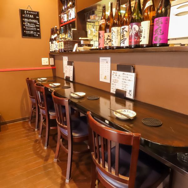 【1階カウンター席】お仕事帰りのちょい飲みや、お休みの日の飲み歩きにも、お1人様から気軽にご利用いただけるカウンター席もご用意しております。気さくなスタッフとのコミュニケーションも楽しみながら、おいしいお酒と魚料理で至福のひとときをお過ごしください！