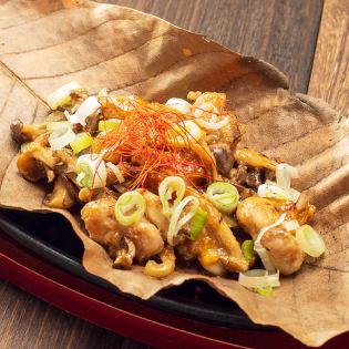 Chicken shoulder and two kinds of mushrooms grilled on a magnolia leaf
