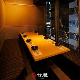 ［6～8名様：半個室］木目の美しいテーブルとシックな内装が織り成す半個室。静けさと落ち着きに満ちた設えで、窓の向こうに広がる外の景色が、特別なものへと導く、寛ぎと美意識が息づく特別席です。