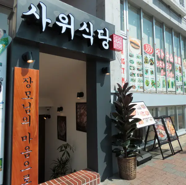 まるでソウルの街角に迷い込んだような、洗練された韓国料理店の外観です。大きな韓国語の看板が目を引き、期待感を高めます。店内へ誘う入り口は、異国情緒あふれる雰囲気で、本格的な韓国料理の世界へと誘います。