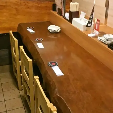 我们也准备了方便单人用餐的吧台座位。柜台旁边摆放着一排排小町的招牌酒。吧台座位充满着温馨的氛围。柜台座位每次仅限一组人入座。