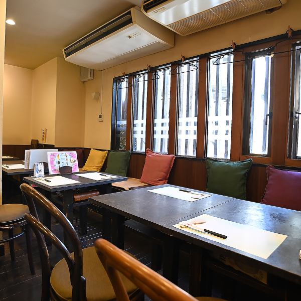 4名掛け×3卓、2名掛け×1卓のテーブル席は、友人同士や同僚との食事にぴったり。ゆったりとした間隔で配置されており、周囲を気にせず会話を楽しめます。木のテーブルとカラフルなクッションが、温かみのある空間を演出。貸切利用も17名から可能なので、会社の飲み会や小規模な宴会にもおすすめです！