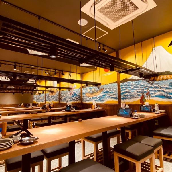 和の風情が漂う当店は、海をテーマにしたアートが印象的。温かい照明に包まれた空間で、木の温もりを感じながら心安らぐひとときをお過ごしください。壁に並ぶ厳選地酒の瓶が、豊富なメニューを予感させ居心地の良い雰囲気を作り出します。お酒に合うメニューも豊富にご用意しております。