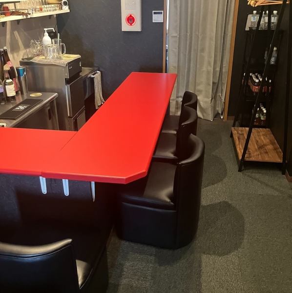 鮮やかな赤が目を引くカウンター席を5席完備しています。シックな黒の壁面とモダンなコントラストを描く空間は、お仕事帰りの一杯や大人のデートに最適。スタッフとの会話を楽しみながら、ゆったりとお酒を嗜むのにぴったりのお席です。