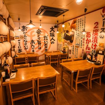 テーブル席は、温かみのある木の素材で統一され、落ち着いた雰囲気を演出しています。広々としたスペースで、友人や家族との食事を楽しむのに最適です。壁にはユニークなメッセージが施され、楽しい会話を引き立てます。