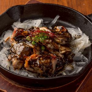 Charcoal-grilled chicken skin on an iron plate