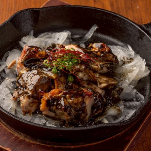 Charcoal-grilled chicken skin on an iron plate