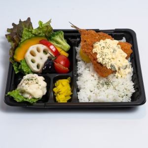 Large fried horse mackerel with homemade tartar sauce and healthy vegetables in a bento box