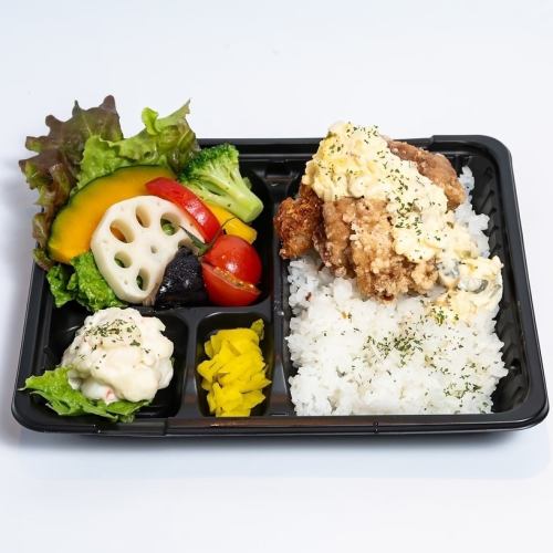 Juicy fried chicken with homemade tartar sauce and healthy vegetables in a bento box