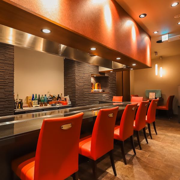 【五感で楽しむカウンター席】赤と黒を基調としたシンプルなデザイン。その洗練されたスタイリッシュさからも「鉄板焼き」の概念を覆す雰囲気を感じ取れます。カウンターに使用しているのは黒の大理石と、店主特注の4mにもなる鉄板。目の前で繰り広げられる調理の様子は圧巻！目で、香りで、舌でお料理をご堪能ください。