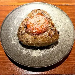 Grilled rice ball with egg yolk and Pecorino cheese.