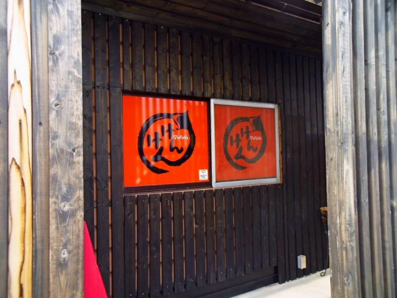 Signboard with orange signature is a landmark.There is a wide parking lot of sharing.There is a large TV in the shop.