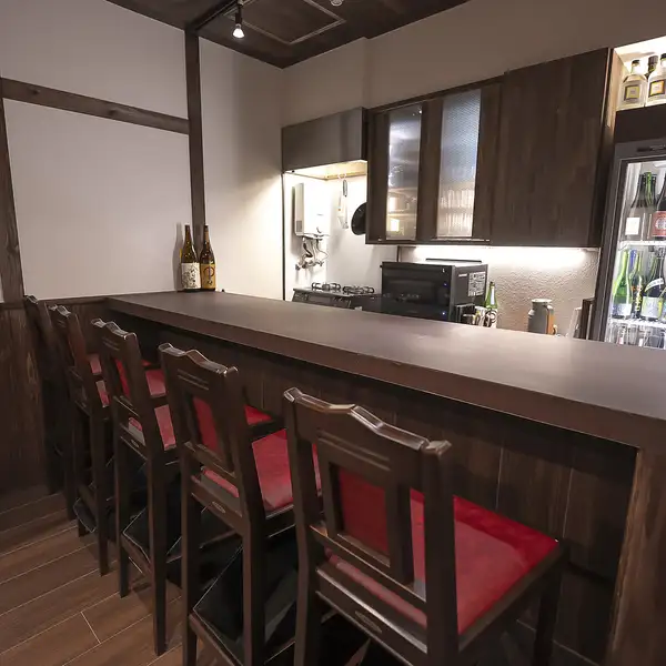 カウンター席やテーブル席は、少人数での利用に最適。日本酒が並ぶ冷蔵庫を眺めながら、店主との会話を楽しめるカウンター席は特に人気です。落ち着いた雰囲気で、ゆっくりと食事とお酒を楽しめる空間を提供しています。デートや友人との食事にもおすすめです。落ち着いた照明が心地よい時間を演出します。