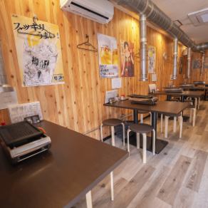 木の温もりに包まれたテーブル席は、友人や同僚と網を囲み、賑やかに時間を過ごすのに最適な空間です。壁に並ぶレトロなポスターが醸し出すアットホームな雰囲気の中で、気兼ねなく会話が弾みます。広々とした卓上には専用の焼き台を完備。美味しい鶏焼肉を通じて、仲間との絆もなめらかに深まるはずです。