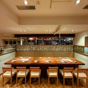 木の温もりを感じる店内全体のテーブル席。新橋駅徒歩3分の好立地で、和牛や新鮮な海鮮料理を囲みながら、仕事帰りの集まりにも使いやすい空間です。