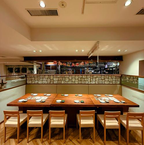 木の温もりを感じる店内全体のテーブル席。新橋駅徒歩3分の好立地で、和牛や新鮮な海鮮料理を囲みながら、仕事帰りの集まりにも使いやすい空間です。