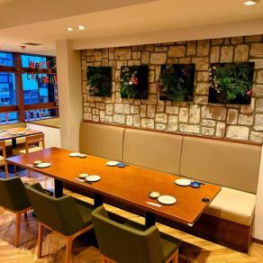 壁面の装飾が印象的なソファータイプのテーブル席。ゆったり腰掛けられるため、長時間の食事でも快適に過ごせます。落ち着いた雰囲気で、食事会や女子会など幅広いシーンにおすすめです。