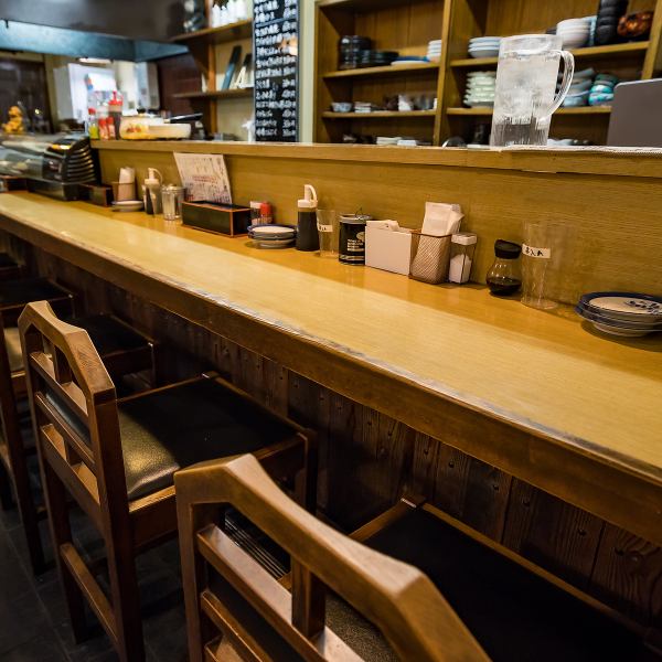 カウンター席は木目調の長い一枚板に、ゆったりとした椅子を配置。目の前で調理の様子が見られ、スタッフとの会話も楽しめる特等席です。仕事帰りにふらっと立ち寄って、串カツとハイボールで一息つくのにぴったりな空間です。