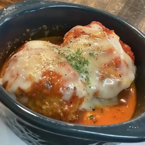 Chicken meatballs simmered in tomato sauce (topped with cheese)