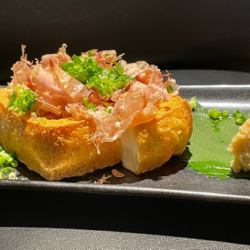 Thick fried tofu topped with green onions and bonito flakes