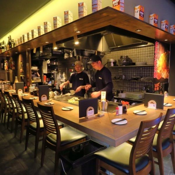 【カウンター席】当店自慢のカウンター席では、目の前でプロの技が繰り広げられる臨場感をお楽しみいただけます。鉄板が近く、焼き上がるお好み焼きの香ばしい香りが漂う中、シェフの手さばきを間近で見ることができます。定番の広島スタイルを、熱々の状態で味わえる贅沢なひとときを是非お過ごしください！