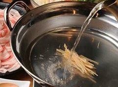 享用由蛤蜊、海帶和生薑製成的金湯火鍋。