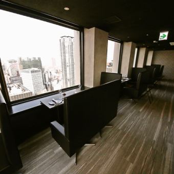 【窓際カップルシート】最上階33階からの景色を目の前に鉄板焼を同時にお楽しみいただける2名様用のお席です。食事がゆったりと楽しめるソファ席はデート利用におすすめ。※チャージ1000円/名
