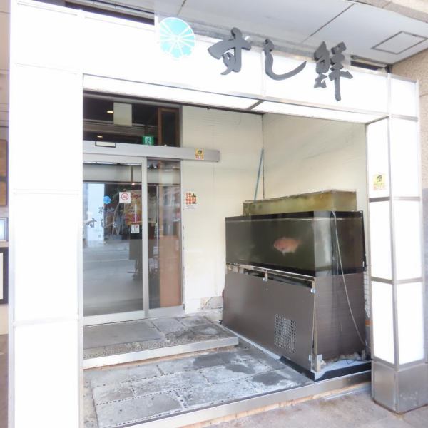 店先に堂々と置かれた生け簀が存在感を放ち、通りからでも鮮度の良さをしっかり伝えてくれる外観♪ シンプルで清潔感のある入口は、ガラス扉越しに店内の様子が見えて安心感も抜群◎ 初めての方でも迷わず入りやすい雰囲気で、ふらりと立ち寄りたくなる佇まいですよ。皆さまのご来店を心よりお待ちしております！