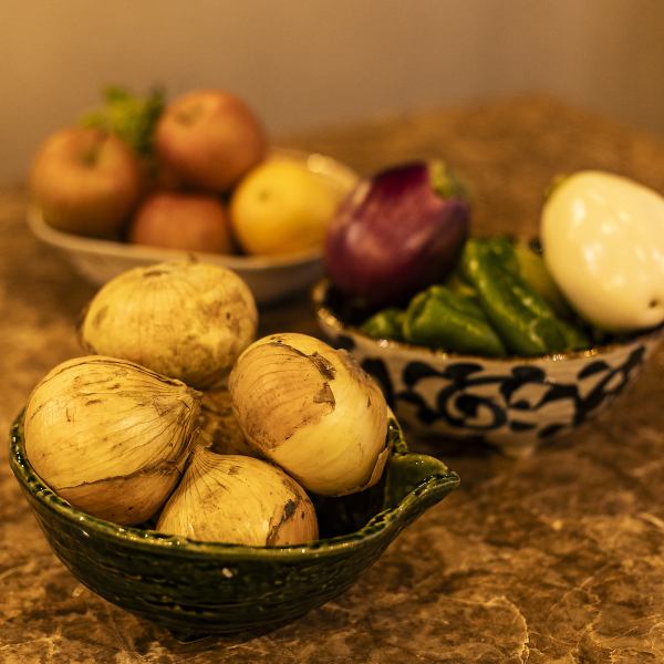 新鮮でみずみずしい旬の野菜や果物たち。産地から届いたばかりの玉ねぎやピーマン、そして季節の果物が、当店の食へのこだわりを物語っています。大地の恵みをたっぷり受けた自然な甘みと旨み。新鮮な食材を使った当店の自慢の味をぜひご賞味ください。