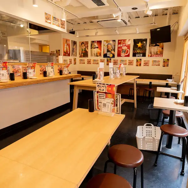 清潔感のあるモダンな造りながら、どこか懐かしい居酒屋情緒が漂う店内です。窓際の席からは外の通りが見渡せ、開放感に浸りながら一杯楽しめます。足元には荷物置きのバスケットが完備されるなど、細かな配慮も嬉しいポイントです。名物の「せんべろセット」の案内が目を引き、次の一杯が待ち遠しくなる心地よい空間です。