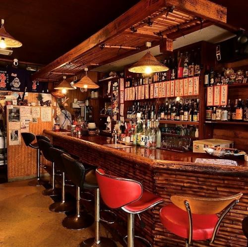 <p>【カウンター席：8名】竹を基調とした落ち着いたカウンター席は、お一人様でもしっとりとお酒を楽しめる空間。全8席のゆとりある配置で、仕事帰りのサク飲みや普段のお食事にも最適です。目の前に並ぶ豊富な泡盛を眺めながら、沖縄おでんが染み渡る至福のひと時を。</p>