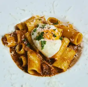 Game meat ragu pasta with a soft-boiled egg.