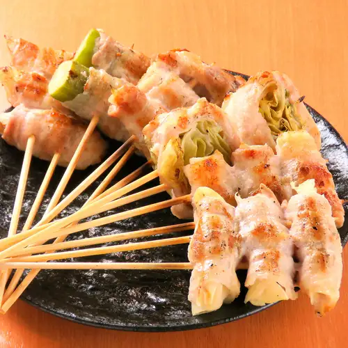 Charcoal-grilled meat-wrapped vegetable skewers