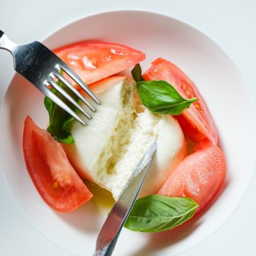 Caprese made with domestic Amera tomatoes and burrata cheese