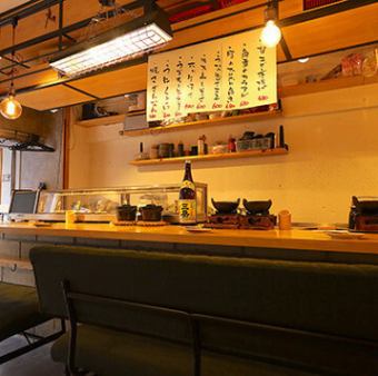 ゆったりとした緑のソファが目を引くカウンター席は、まさに大人の隠れ家☆目の前で調理されるライブ感を楽しみながら、肩を並べて語り合える贅沢な空間です♪柔らかな裸電球の光が、グラスに注がれたお酒を美しく照らします★デートやお仕事帰りのご褒美に、しっとりと落ち着いた雰囲気に身を委ねてみませんか◎